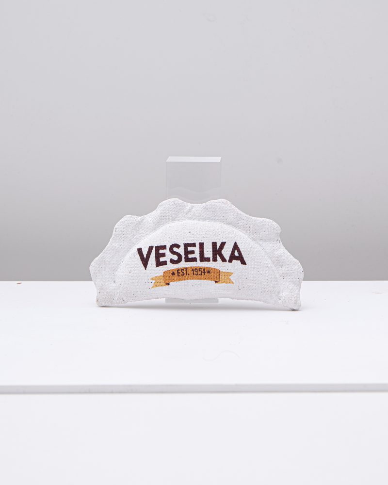 Rzeźbiona pamiątka w kształcie pieroga z logo Veselka